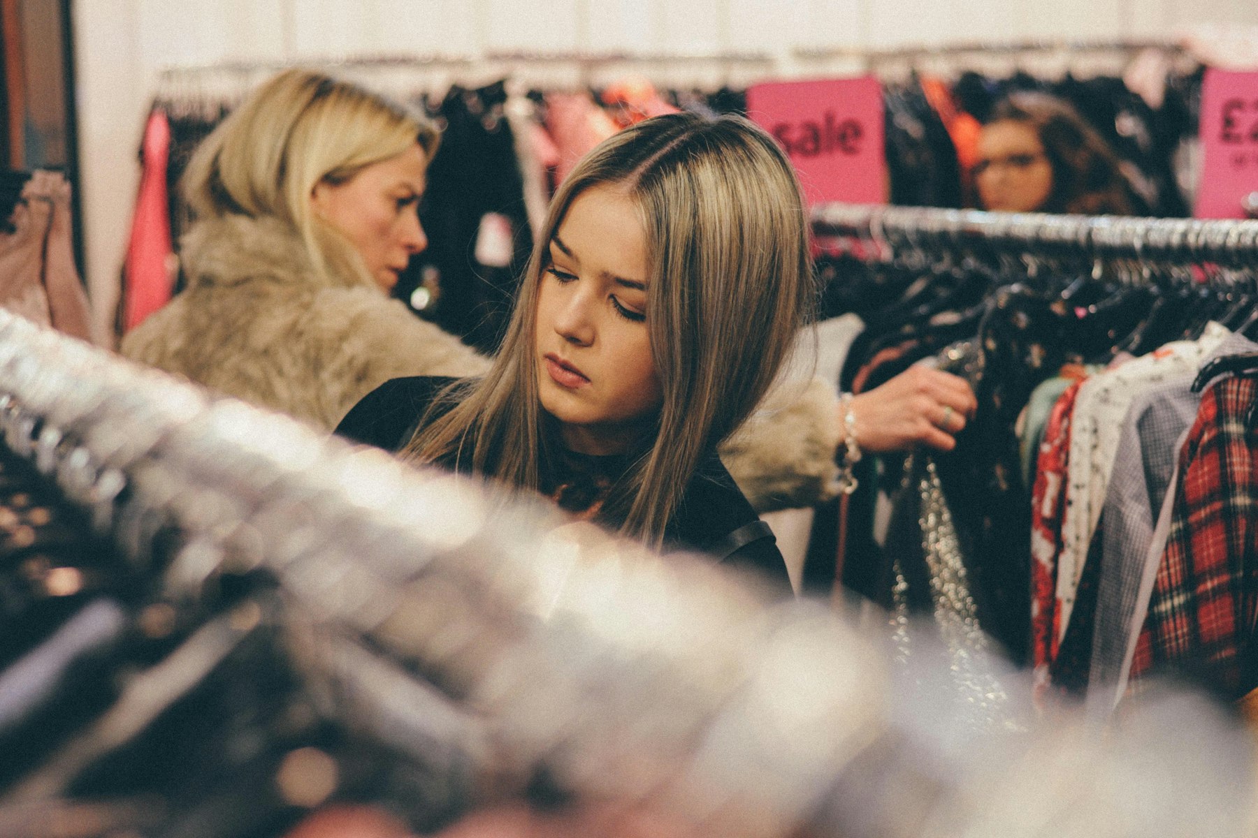 Two women in the boutique looking through a rack of clothing together