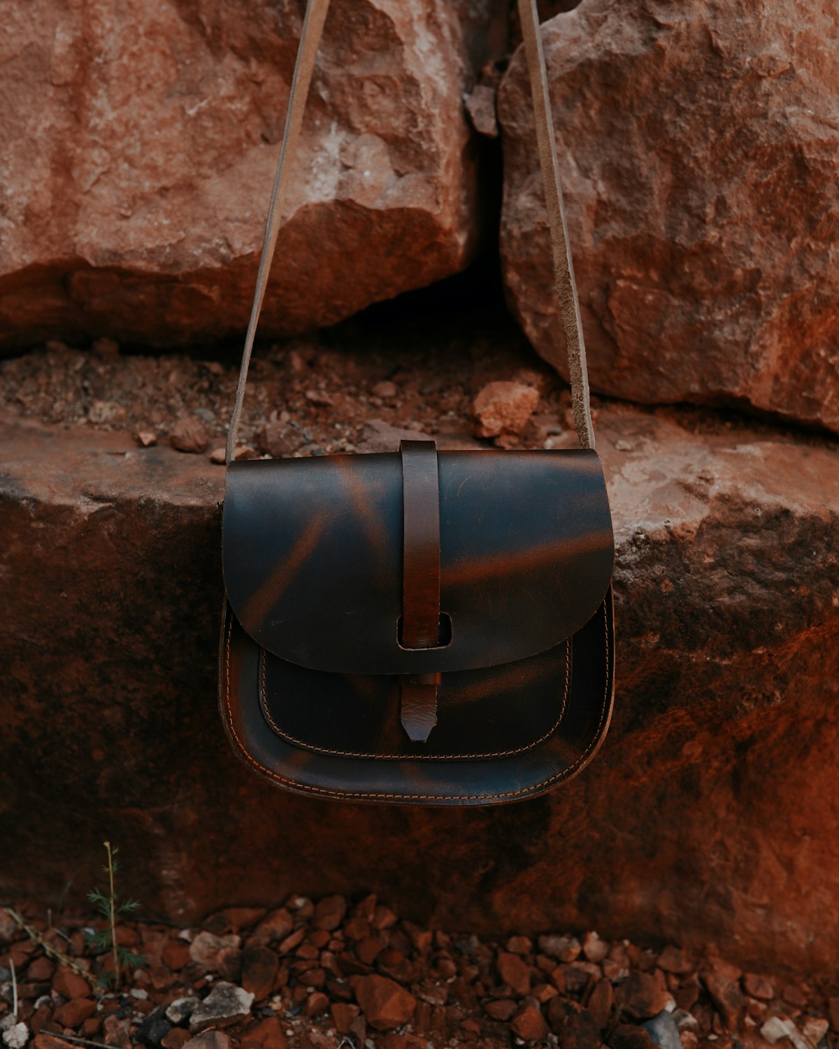 Cognac leather saddle bag with a flap closure and a long crossbody strap