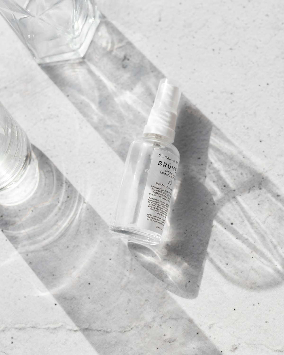 Clear glass room spray bottle with a white label and a mist sprayer